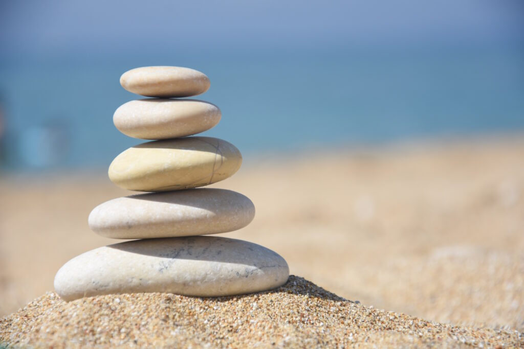 Balanced stone pyramid on sand on beach. Zen rock, concept of ba